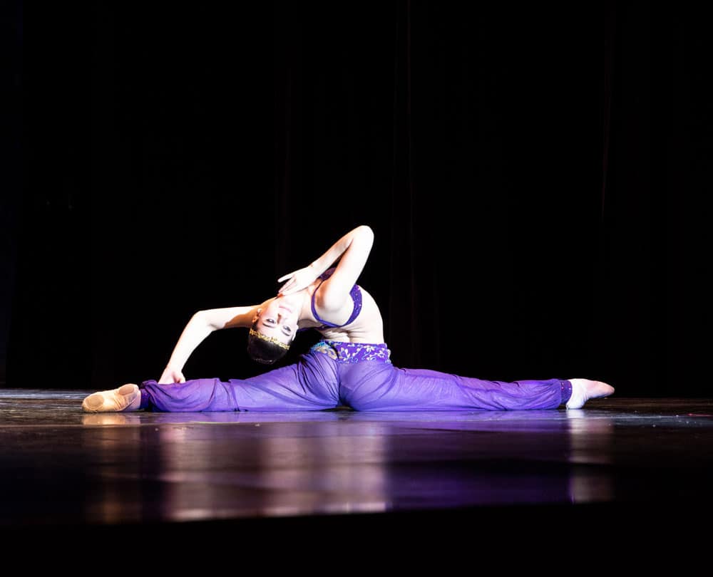 Arabian dancer in The Nutcracker doing the splits bending all the way back to head touching back leg.