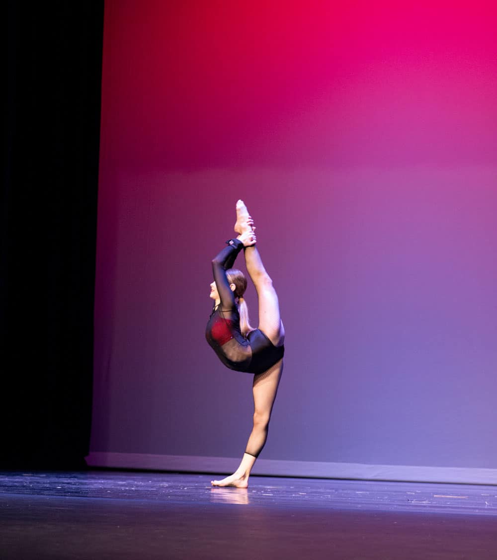 Solo lyrical dancer doing an extended scorpion on the dance stage for competition.