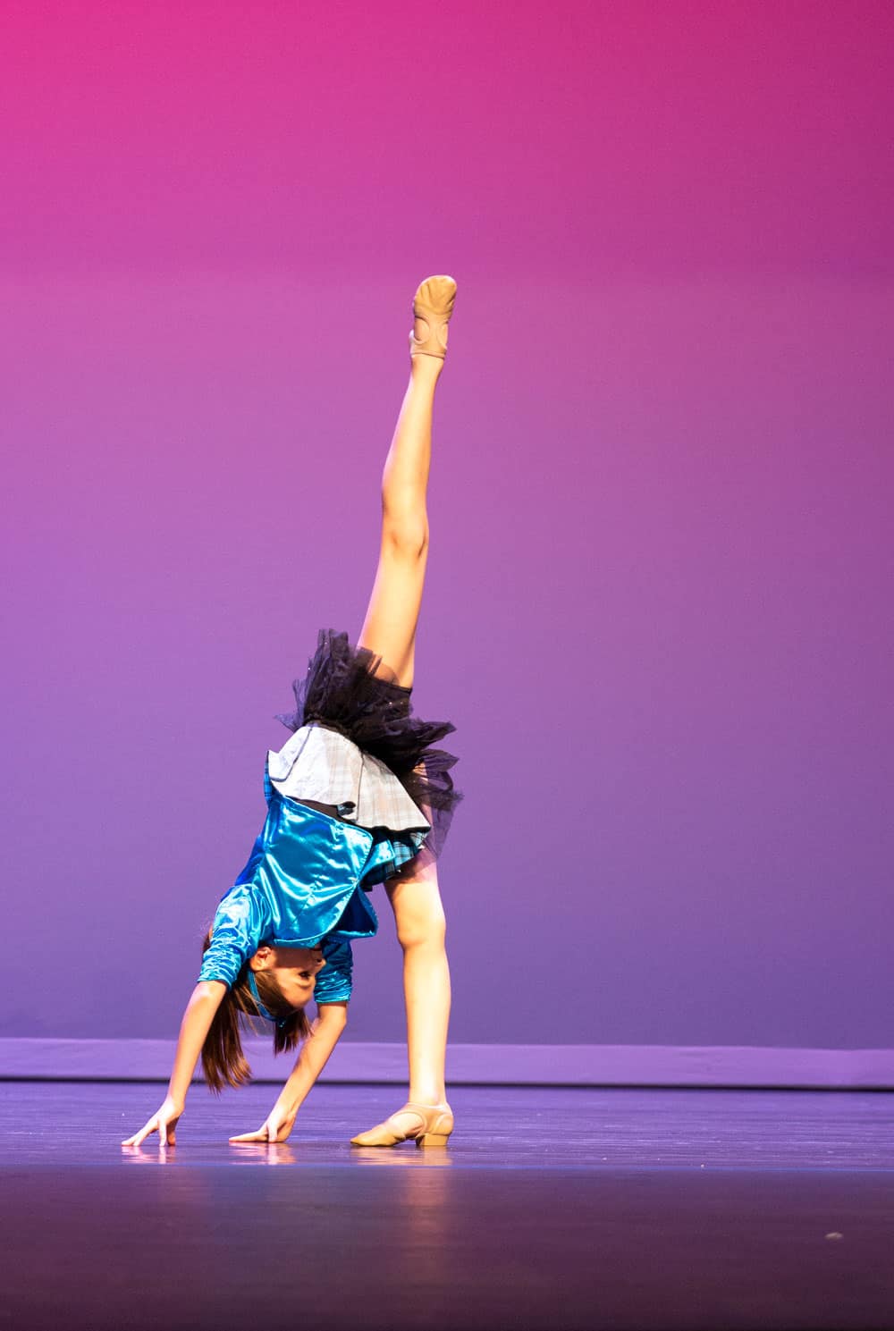 Jazz solo dancer doing a needle on stage for a dance competition performance.