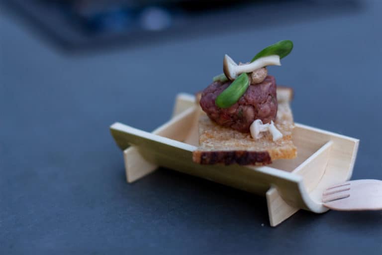 Rovey Dairy Wagyu Beef Tartar on a wooden serving dish, fork on side.