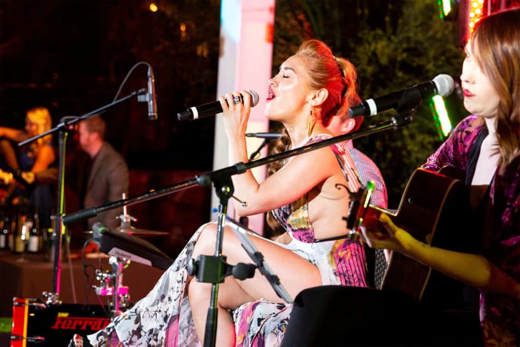 Angela Ferrari singing on stage at an event in Scottsdale, Arizona.